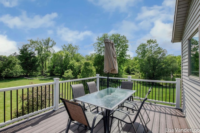1706 Steff Ct SW, Wyoming, MI 49519 - wooden terrace featuring outdoor dining space, a lawn, and view of wooded area