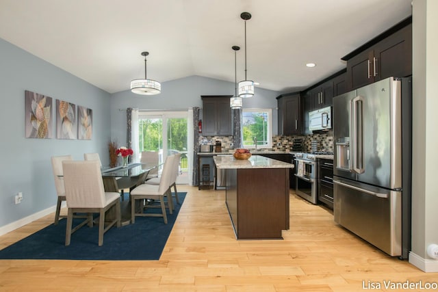 1706 Steff Ct SW, Wyoming, MI 49519 - kitchen with premium appliances, a kitchen island, light wood-type flooring, lofted ceiling, and backsplash