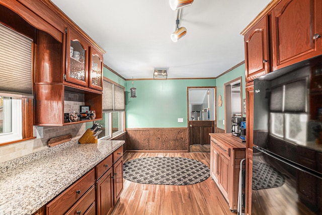 16 E Pine St, Fremont, MI 49412 - kitchen featuring freestanding refrigerator, wainscoting, light wood-type flooring, glass insert cabinets, and crown molding