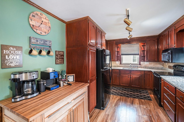 16 E Pine St, Fremont, MI 49412 - kitchen with black appliances, wood finished floors, open shelves, and decorative backsplash
