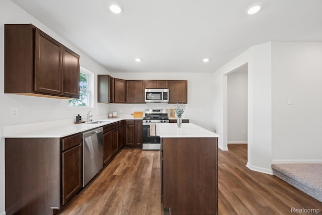 4311 Oak St, Grand Blanc, MI 48439 - kitchen featuring stainless steel appliances, a kitchen island, light countertops, recessed lighting, and dark wood-type flooring