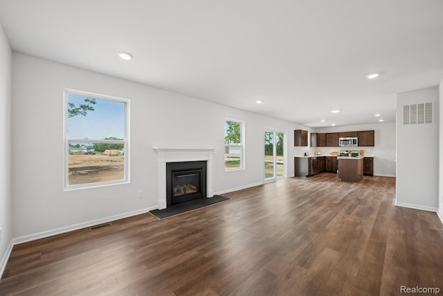 4311 Oak St, Grand Blanc, MI 48439 - unfurnished living room featuring dark wood-type flooring, recessed lighting, and a glass covered fireplace