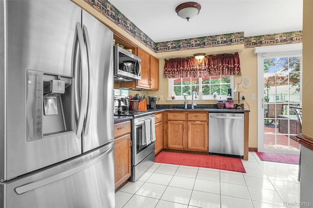 54286 Bradshaw Dr, New Baltimore, MI 48047 - kitchen featuring stainless steel appliances, dark countertops, brown cabinetry, and light tile patterned floors
