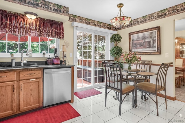 54286 Bradshaw Dr, New Baltimore, MI 48047 - kitchen featuring stainless steel dishwasher, dark countertops, light tile patterned floors, brown cabinets, and a chandelier