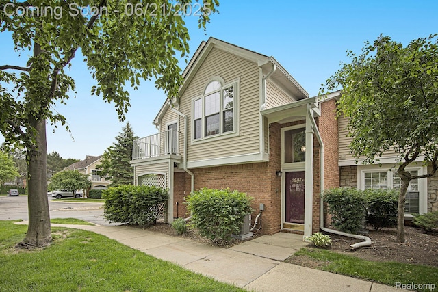 56217 Troon N, Utica, MI 48316 - tri-level home with a balcony, brick siding, and a front yard