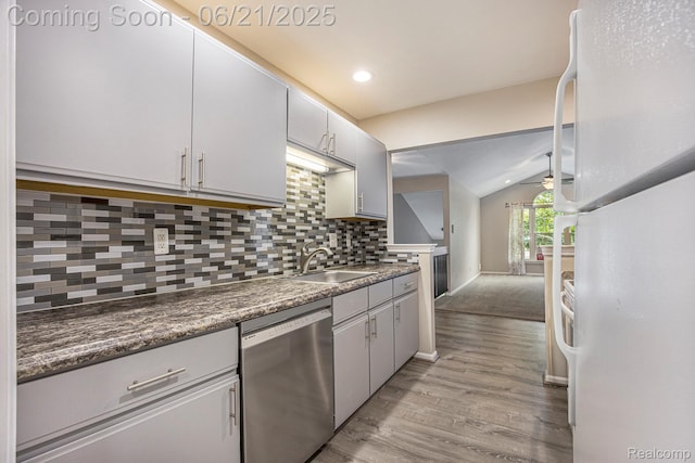 56217 Troon N, Utica, MI 48316 - kitchen with stainless steel dishwasher, freestanding refrigerator, lofted ceiling, light wood-style flooring, and decorative backsplash