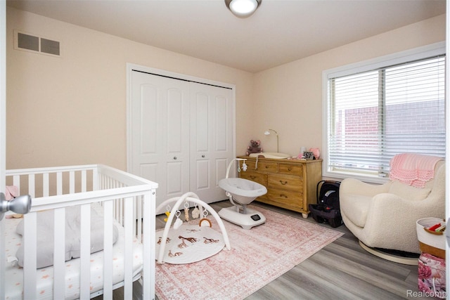 52854 Schafers Run Ct, New Baltimore, MI 48051 - bedroom featuring a closet, wood finished floors, and a nursery area