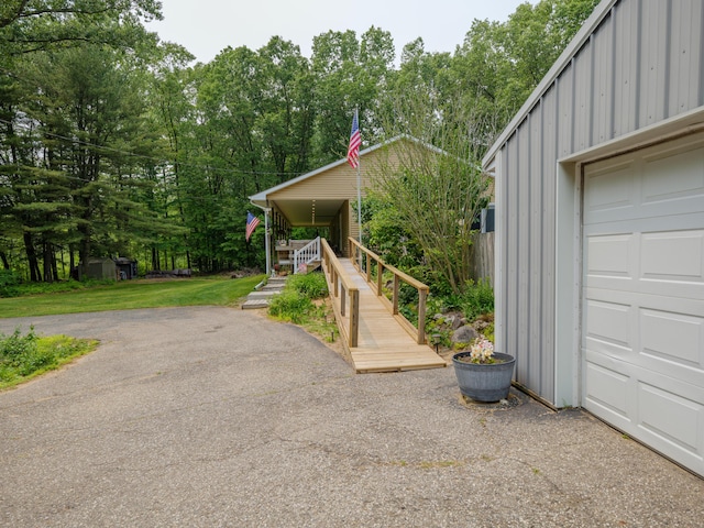 55840 Western Ave, Mattawan, MI 49071 - view of home's exterior featuring board and batten siding, stairway, a garage, and view of wooded area
