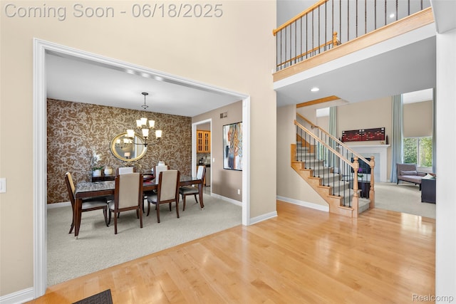 392 Gunston Ct, Troy, MI 48083 - dining room featuring wallpapered walls, stairs, a chandelier, wood finished floors, and an accent wall