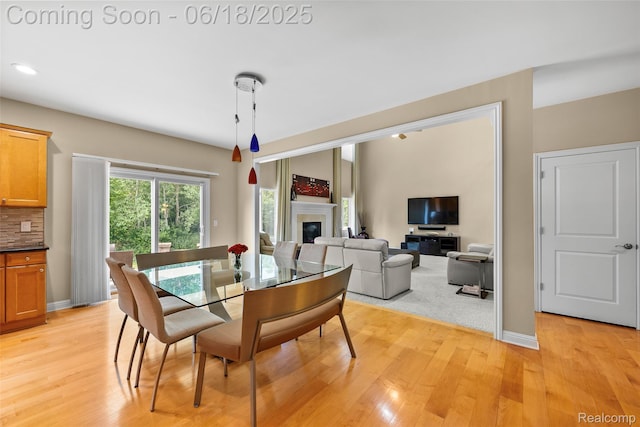 392 Gunston Ct, Troy, MI 48083 - dining space featuring light wood finished floors, a glass covered fireplace, and recessed lighting
