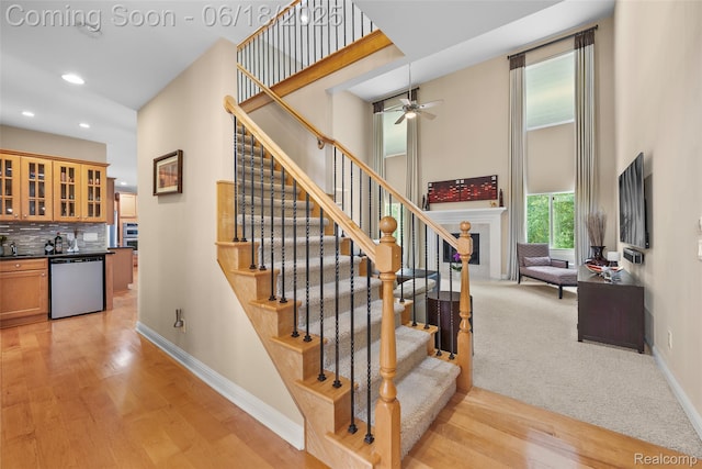 392 Gunston Ct, Troy, MI 48083 - staircase with a high ceiling, wood finished floors, bar area, a ceiling fan, and recessed lighting