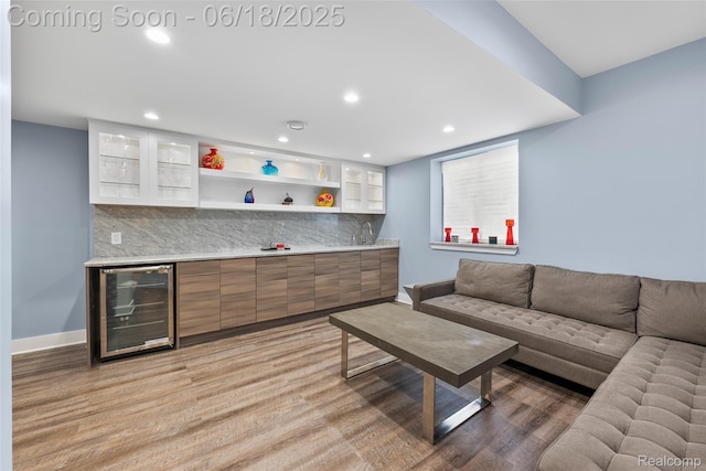 392 Gunston Ct, Troy, MI 48083 - living area featuring beverage cooler, bar with sink, light wood-type flooring, and recessed lighting