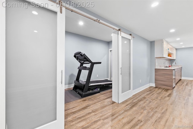 392 Gunston Ct, Troy, MI 48083 - workout room featuring light wood-style floors, a barn door, and recessed lighting