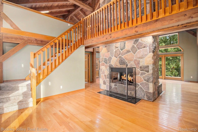 3278 Warner Rd, Howell, MI 48855 - unfurnished living room with high vaulted ceiling, wood finished floors, stairway, and a wooden ceiling with exposed beams