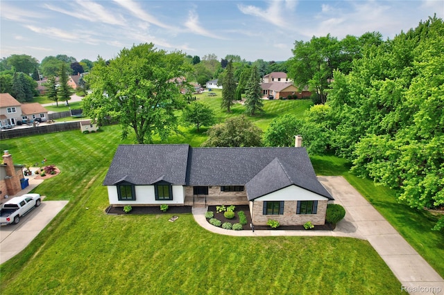 507 Charing Cross Dr, Grand Blanc, MI 48439 - view of front of property featuring a front yard, roof with shingles, stone siding, view of scattered trees, and concrete driveway