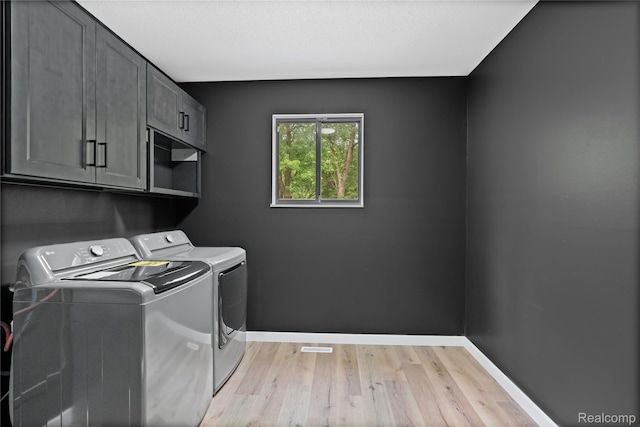 507 Charing Cross Dr, Grand Blanc, MI 48439 - laundry room featuring cabinet space, washer and dryer, and light wood-type flooring