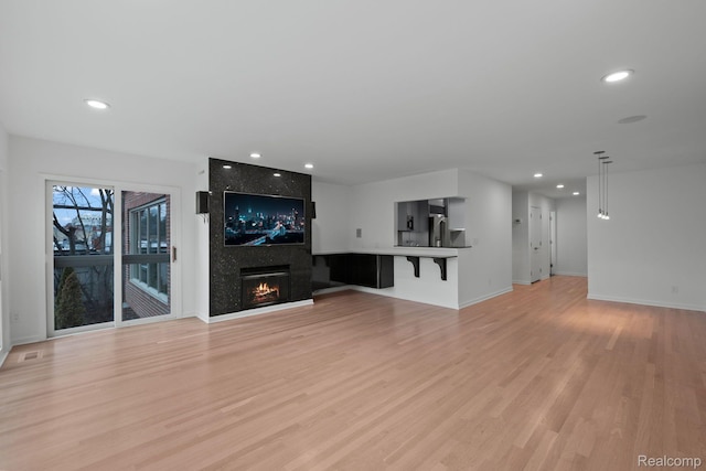 511 Brookside Ave, Birmingham, MI 48009 - unfurnished living room with light wood-type flooring, recessed lighting, and a large fireplace