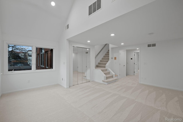 511 Brookside Ave, Birmingham, MI 48009 - unfurnished living room featuring light carpet, stairway, recessed lighting, and a towering ceiling