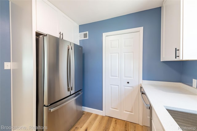24251 Cloverlawn St, Oak Park, MI 48237 - kitchen featuring appliances with stainless steel finishes, white cabinets, and light wood finished floors