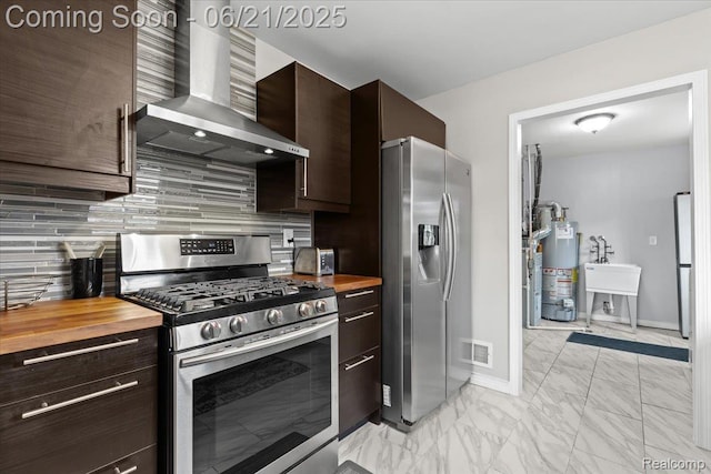 30546 Townley St, Madison Heights, MI 48071 - kitchen featuring wall chimney exhaust hood, stainless steel appliances, wooden counters, and gas water heater