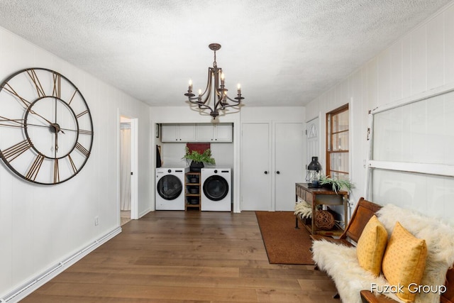 4733 136th Ave, Hamilton, MI 49419 - washroom featuring washer and clothes dryer, dark wood-style floors, a chandelier, a textured ceiling, and cabinet space
