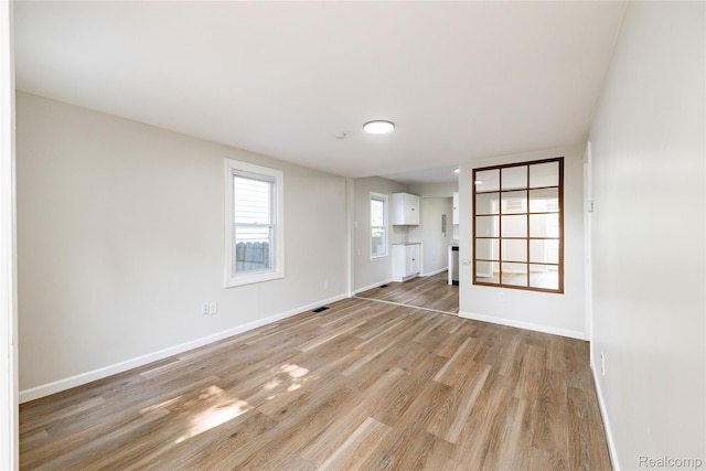 3820 17th St, Grosse Ile, MI 48192 - unfurnished living room with light wood-style floors and baseboards