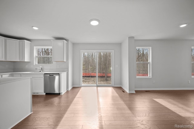 4286 Oak St, Grand Blanc, MI 48439 - kitchen with stainless steel dishwasher, hardwood / wood-style floors, light countertops, white cabinets, and recessed lighting