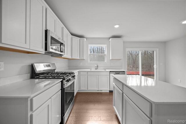 4286 Oak St, Grand Blanc, MI 48439 - kitchen featuring stainless steel appliances, light countertops, wood finished floors, white cabinets, and recessed lighting