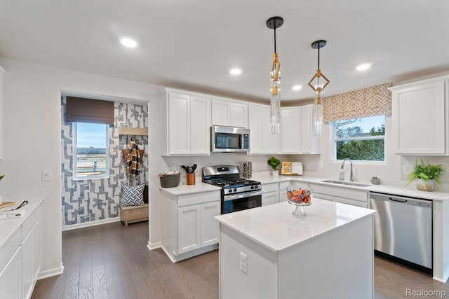 4286 Oak St, Grand Blanc, MI 48439 - kitchen with appliances with stainless steel finishes, light countertops, white cabinets, dark wood-style floors, and hanging light fixtures