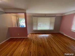 8889 Plainview Ave, Detroit, MI 48228 - unfurnished living room with baseboards and wood finished floors