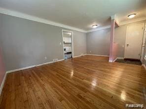 8889 Plainview Ave, Detroit, MI 48228 - unfurnished living room with wood finished floors and crown molding