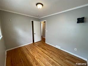 8889 Plainview Ave, Detroit, MI 48228 - spare room with crown molding and wood finished floors