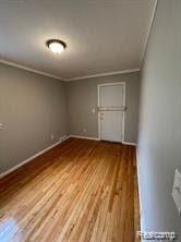 8889 Plainview Ave, Detroit, MI 48228 - spare room featuring wood finished floors and ornamental molding