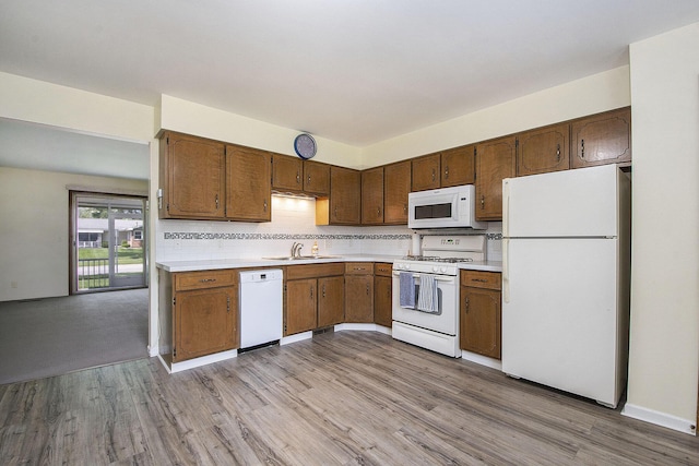 880 Andover Ct SE, Grand Rapids, MI 49508 - kitchen with white appliances, light wood-type flooring, light countertops, and backsplash