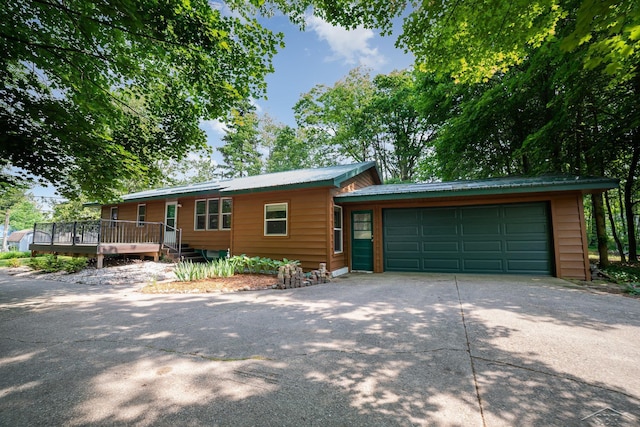 441 Hillcrest Dr, Lake, MI 48632 - view of front of property featuring driveway, a garage, a metal roof, and a deck