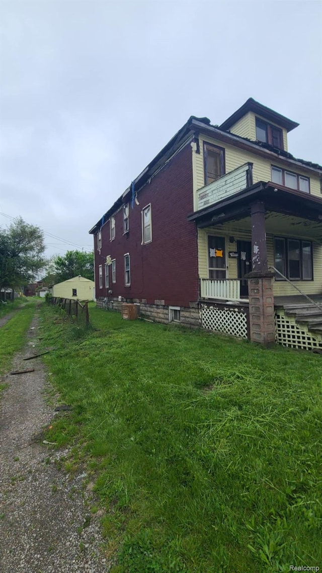 193 Division St, River Rouge, MI 48218 - view of side of property with a porch, brick siding, and a lawn
