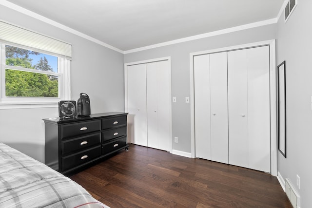 833 S Lansing St, Mason, MI 48854 - bedroom featuring two closets, dark wood finished floors, and ornamental molding