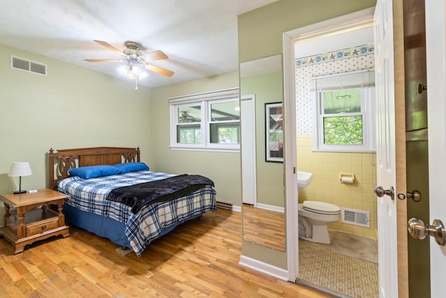833 S Lansing St, Mason, MI 48854 - bedroom with multiple windows, light wood-style flooring, ensuite bathroom, and a ceiling fan
