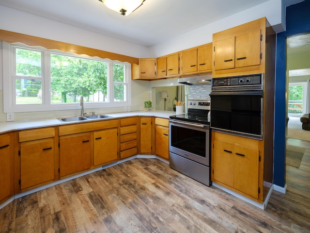 7061 W N Ave, Kalamazoo, MI 49009 - kitchen featuring electric range, oven, light wood-style floors, under cabinet range hood, and decorative backsplash