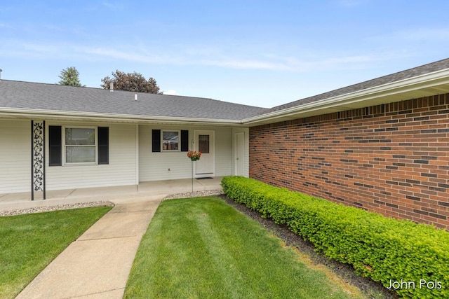 2913 N Wentward Ct, Hudsonville, MI 49426 - view of exterior entry featuring a lawn, brick siding, and a porch