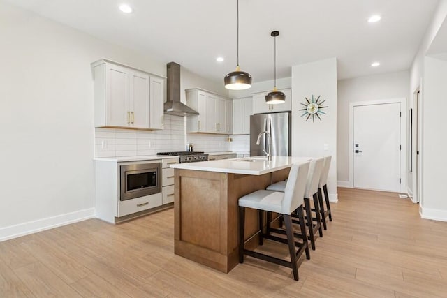 929 Harbor Dr E # 27, Saint Joseph, MI 49085 - kitchen with wall chimney range hood, appliances with stainless steel finishes, light countertops, tasteful backsplash, and a breakfast bar