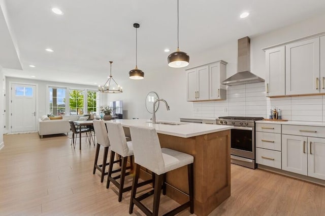 929 Harbor Dr E # 27, Saint Joseph, MI 49085 - kitchen with wall chimney range hood, stainless steel gas range, light wood-style flooring, light countertops, and recessed lighting