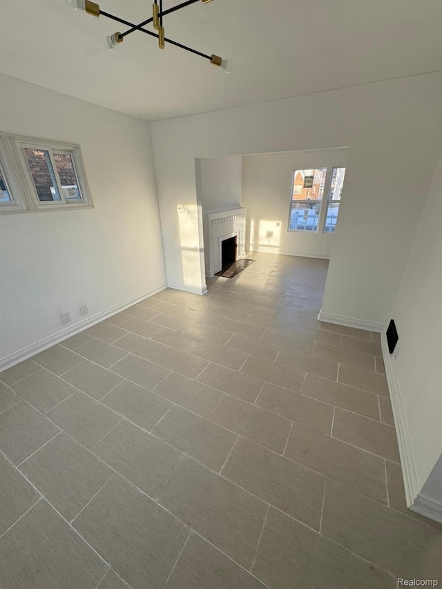 4707 Buckingham Ave, Detroit, MI 48224 - unfurnished living room featuring a brick fireplace and a chandelier