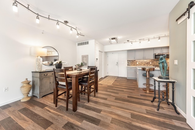 293 N 2nd St Unit 201, Brighton, MI 48116 - dining area featuring dark wood-style flooring, a barn door, and rail lighting