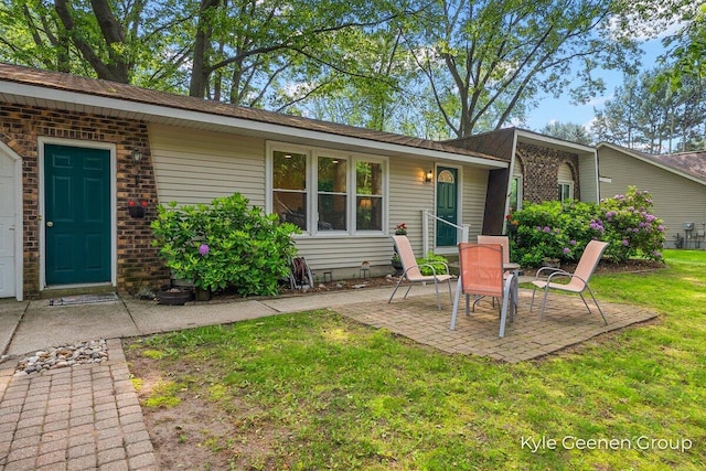 69 Cheyenne Ave, Holland, MI 49424 - view of exterior entry with a lawn and a patio
