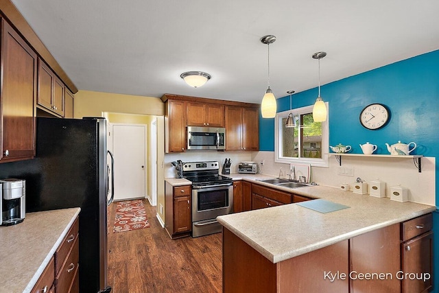 69 Cheyenne Ave, Holland, MI 49424 - kitchen featuring stainless steel appliances, dark wood finished floors, light countertops, and pendant lighting