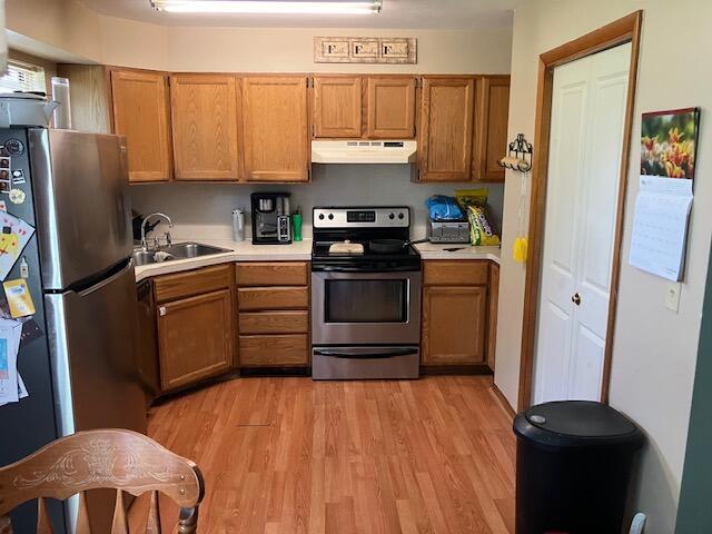 3052 143rd Ave, Dorr, MI 49323 - kitchen with stainless steel appliances, extractor fan, light countertops, light wood-style floors, and brown cabinets