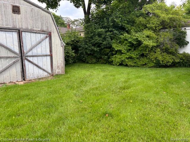 938 Barney Ave, Flint, MI 48503 - view of grassy yard featuring a storage unit
