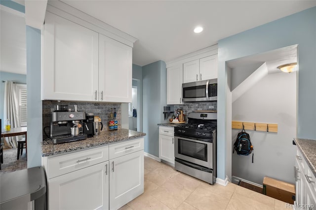 27728 Larchmont St, Saint Clair Shores, MI 48081 - kitchen featuring appliances with stainless steel finishes, backsplash, dark stone countertops, white cabinetry, and recessed lighting