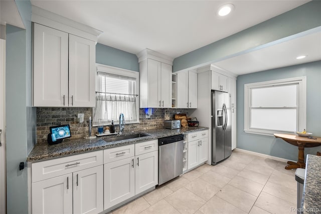 27728 Larchmont St, Saint Clair Shores, MI 48081 - kitchen featuring appliances with stainless steel finishes, backsplash, white cabinetry, dark stone countertops, and light tile patterned floors